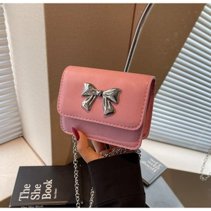 Detail of pink mini chain bag with silver bow buckle and textured faux leather finish
