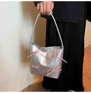 Silberne Metallic-Beuteltasche mit rosa Bandschleifen und schmalem Schulterriemen