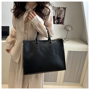 Close-up of black crocodile pattern large tote bag with double handles for women