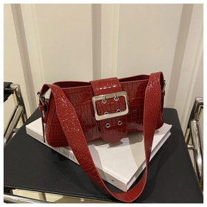 Detail of dark red croc-embossed patent leather bag with a bold silver square buckle