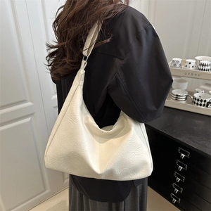 Stylish white faux leather shoulder bag with textured pleats and minimalist crescent design