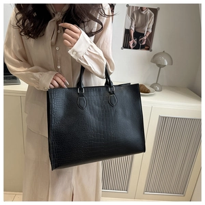 Detailed view of large black crocodile pattern tote bag with double handles for commute