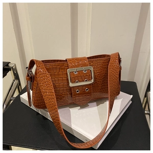 Close-up of brown crocodile texture underarm bag with a large silver square metal buckle