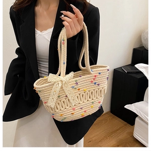 Detail of straw woven bucket bag with colorful polka dots and a lace bow decoration