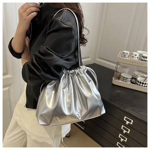 Detail of silver metallic drawstring bucket bag with pleats and a small metal bow
