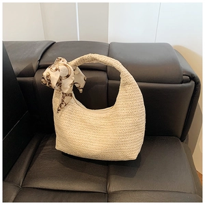 Détail du sac hobo en paille tissée avec une poignée élégante en foulard de soie