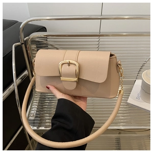 Dettaglio della borsa a spalla beige in ecopelle con grande fibbia quadrata dorata