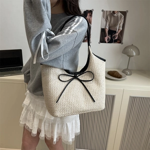 French style woven tote bag with black leather bow detail and long shoulder straps