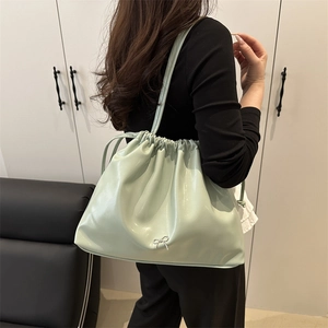 Minimalist mint green pleated bucket bag with silver metal bow and drawstring closure