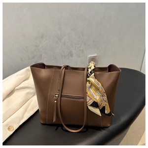 Detailed view of brown large capacity tote bag with decorative silk scarf on handle