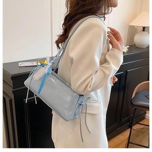 Detalle del bolso de hombro azul claro brillante con detalles de encaje y lazos de cinta