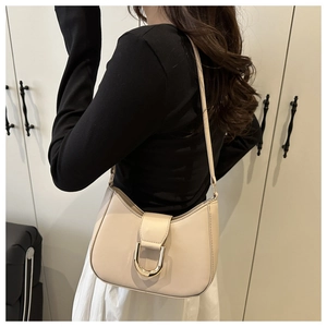 Beige halbmondförmige Schultertasche mit goldener Hufeisenschnalle im Detail
