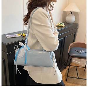 Detalle de bolso de hombro azul claro con lazo de encaje y cordón en un estilo francés