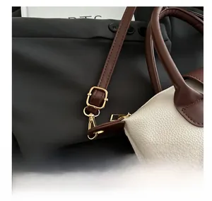 Detail of adjustable gold buckle on off-white lychee texture leather shoulder bag