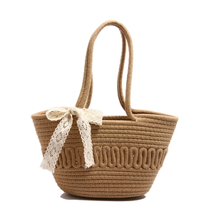 Handcrafted straw bucket bag featuring white lace bow and woven dual shoulder straps