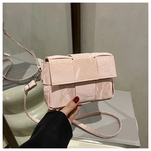Close-up of pink woven texture crossbody bag with marble pattern and silver hardware