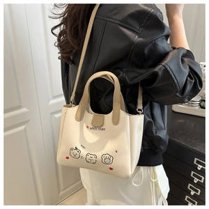 Gros plan du mini sac crème avec motifs d'ours et poignées en similicuir couleur kaki