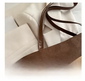 Close-up of brown suede tote bag with heart patch and premium stitching details