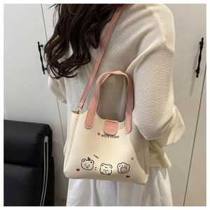 Gros plan du sac beige avec imprimés d'ours et bandoulière réglable rose en situation réelle