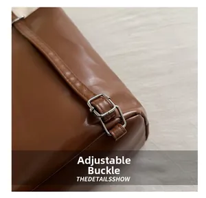 Detail of silver adjustable buckle on brown PU leather strap with precise stitching