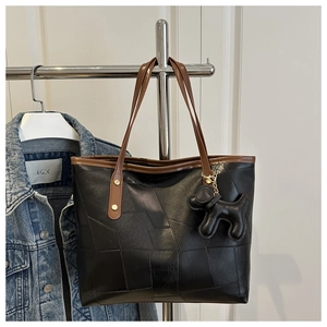 Dettaglio della borsa tote color block con pelle testurizzata e ciondolo a forma di cane