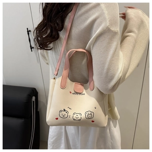 Détail du sac seau blanc crème avec motifs d'ours et poignées roses contrastantes