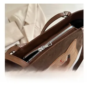 Macro shot of smooth metal zipper and cartoon dog embroidery on a brown tote bag