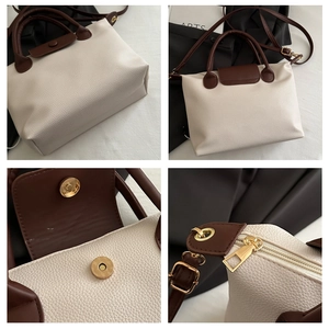 Close-up of pebble leather texture, gold magnetic clasp and zipper detail on tote bag