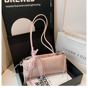 Detalle de bolso rosa con lazo de encaje y cintas en caja de regalo decorativa
