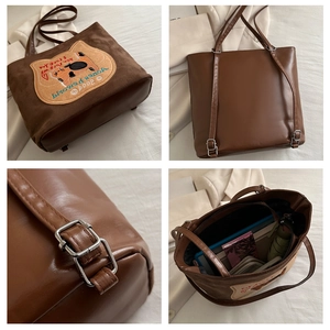Detail view of coffee tote bag showing cartoon cat embroidery and spacious interior capacity
