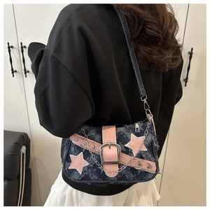 Close-up of Y2K denim shoulder bag with pink leather stars and silver chain detail