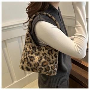 Schicke Plüschtasche mit Leopardenmuster kombiniert mit dunklem Strickoutfit für den Winter