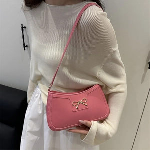 Pink crescent underarm bag for women with gold bow hardware and elegant sleek finish