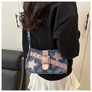Detail van denim schoudertas met sterrenpatroon, roze leren riempjes en zilveren gesp