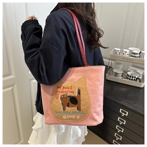 Detail of pink canvas tote featuring a large cat patch embroidery and dual red straps