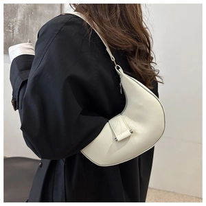 Schicke cremeweiße halbmondförmige Schultertasche mit silbernen Details auf Schwarz