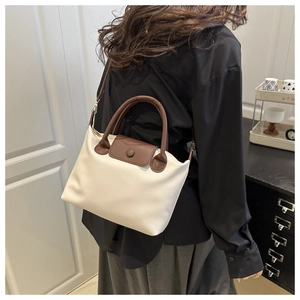 Model view of cream and brown crossbody pillow bag with lychee texture leather detail