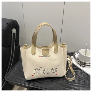 Détails d'un sac cabas blanc crème avec illustration d'ours et poignée élégante