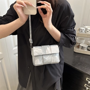 Silver woven crossbody bag with metallic pleated texture and adjustable strap