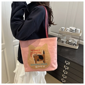 Detail of pink canvas tote bag featuring cat embroidery and durable shoulder strap