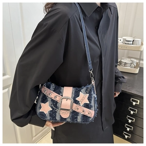 Detail of Y2K denim crossbody bag featuring pink star patches and metallic chain strap