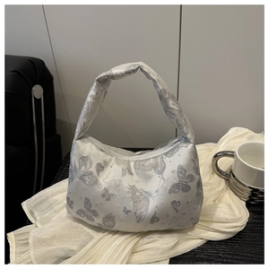 Detail of silver pillow bag with glossy satin fabric and sparkling butterfly patterns