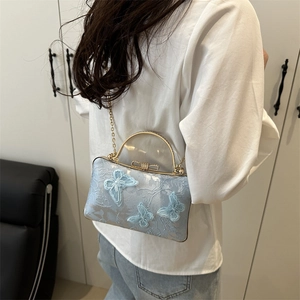 Light blue crossbody box bag featuring 3D butterfly embroidery and transparent top handle