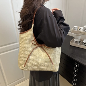 Minimalist woven straw tote bag with brown leather trim and bow knot detail on shoulder