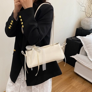 Chic beige patent leather shoulder bag with delicate white lace bow and ruched detailing