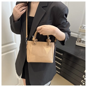 Detail of light brown lychee grain leather square bag with unique knot handle design