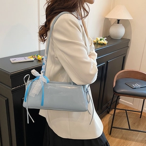 Elegante bolso de hombro azul claro brillante con lazo de encaje en un ambiente hogareño