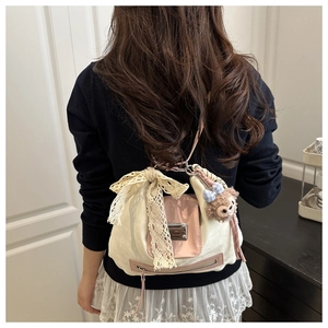 Detail view of pink trim and lace bow on a canvas backpack worn by a model indoors