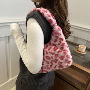 Rosa Schultertasche mit Leopardenmuster aus Kunstpelz, getragen von einem Modell