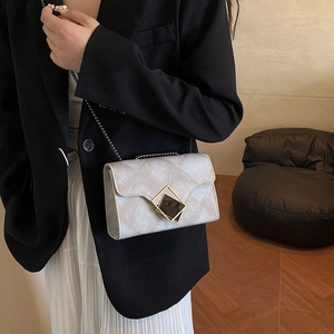 Sac carré gris clair chic avec boucle en losange dorée et bandoulière chaîne sur modèle